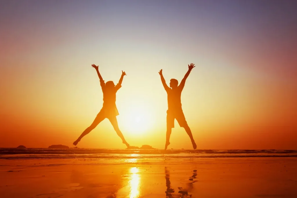 Depiction of people jumping during a sunset